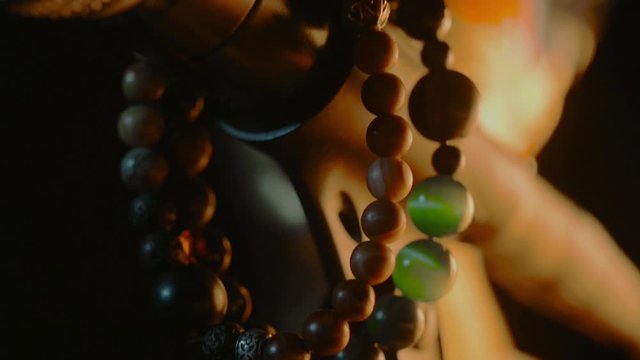 Few semiprecious stone bracelets hanging on a dynamic microphone in a half-light. Close up.