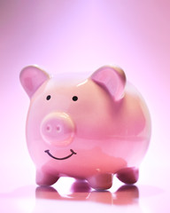 Smiling Piggybank on pink background. Saving money concept.