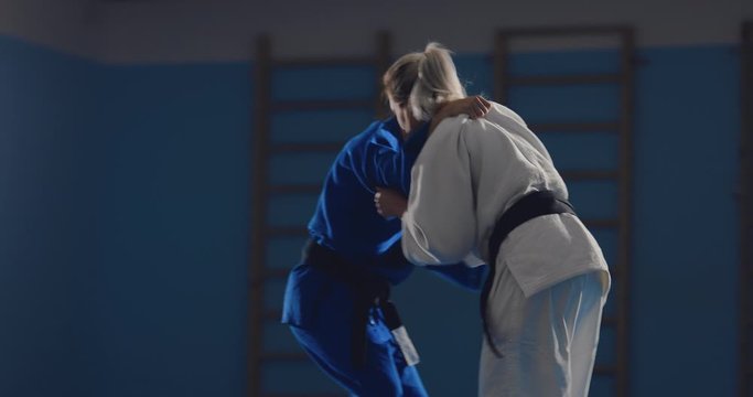 Capturing a fighter, sweeping legs. Fight on the tatami. Judoka in training in the gym.