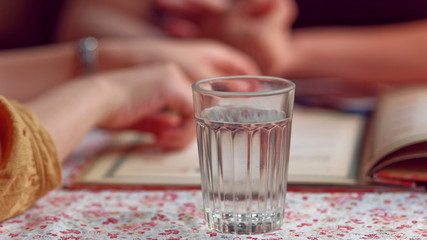 Two beautiful young women in a cafe checking for the menu, close up shot on the glass full of...