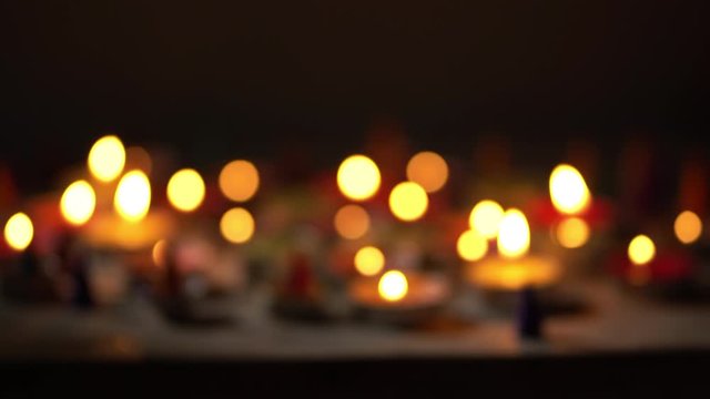 Lighting candle on wood table. Many candle  flames in darkness.Blurred concept.