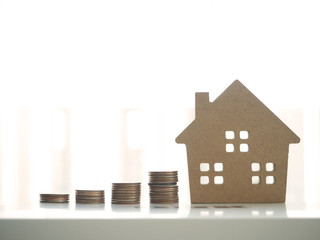 toy business with coin stack with home model, in the concept of business finance