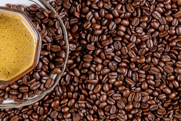 Cup of black coffee and roasted coffee beans.