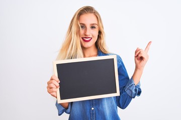 Young beautiful teacher woman holding blackboard standing over isolated white background very happy pointing with hand and finger to the side