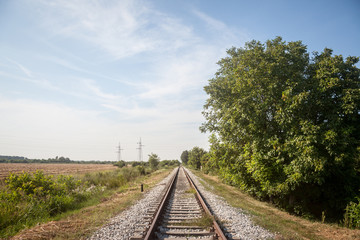 Abandoned railway track, on a defunct line in Serbia, Europe, rusty, surrounded by trees and a...