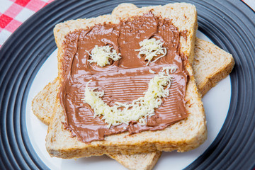 Chocolate cream spread on bread with funny face