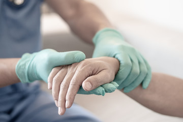 Surgeon, physician performs surgical operations, anesthetist or anesthesiologist holding patient's hand ffor checking state of mand or support in ER room, Medical healthcare concept - obrazy, fototapety, plakaty