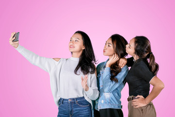 Female teenagers take a selfie photo on studio