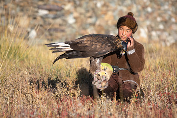 Traditional kazakh eagle huntress with her golden eagle that is used to hunt for fox and rabbit fur. Ulgii, Western Mongolia.