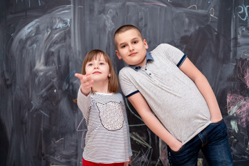 boy and little girl standing in front of chalkboard