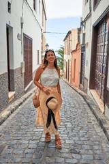 Young beautiful woman on romatic village walking in the middle of the old town street on a sunny day