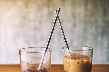 Closeup image of two glasses of iced coffee with stainless steel drinking straw
