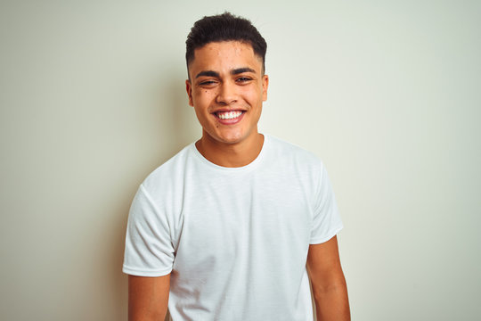 Young brazilian man wearing t-shirt standing over isolated white background with a happy and cool smile on face. Lucky person.