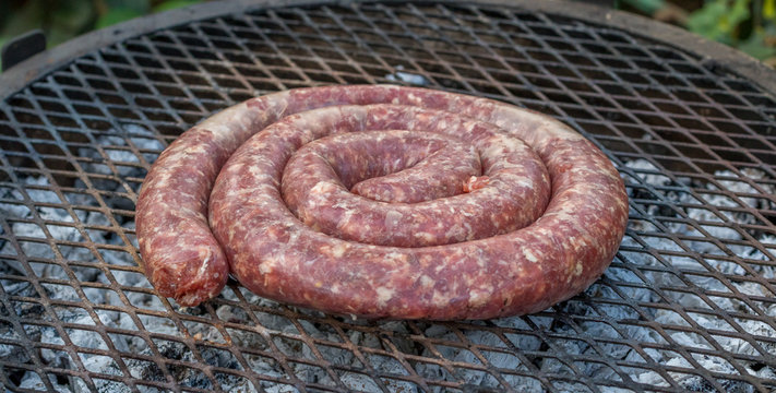 South African boerewors sausage traditionally cooked outdoors on an open fire image with copy space in horizontal format