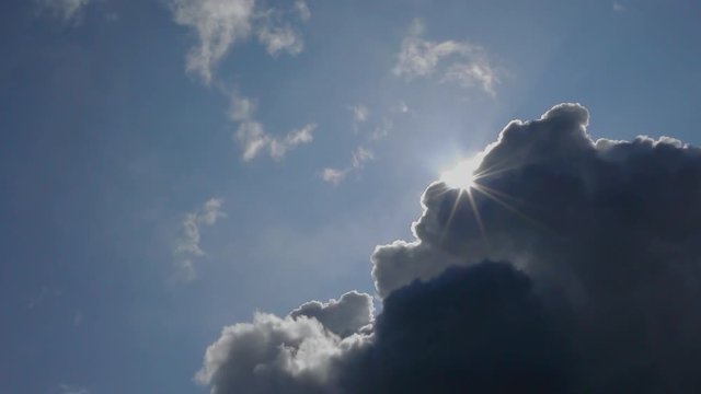 Bright sunlight rays emerging from behind thunder storm cloud
