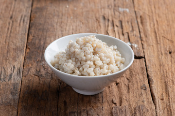 Cooked peeled barley grains in white bowl