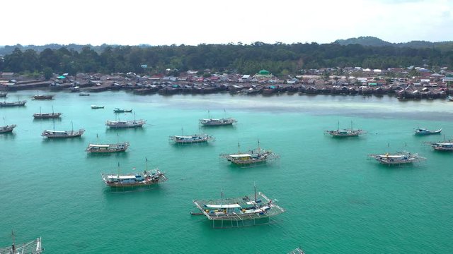 Aerial view of drone fliying over fishing boat at Tanjung Binga fishing Village in Belitung Island Indonesia. Fishing Boat on Clear water.