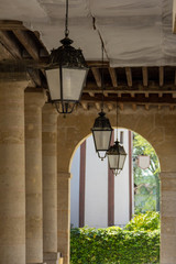 Ornate hanging lamps in a column lined arcade