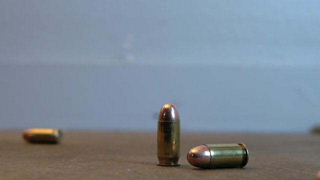 45 caliber pistol ammo rolling on a table