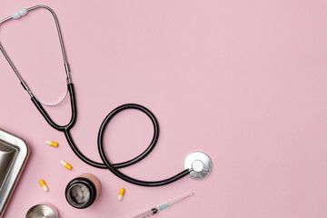 Creative flatlay of doctor medical equipment pink table with stethoscope, medical documents,...