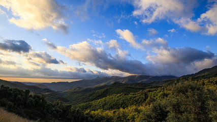 Cloudscape sunrise in Catalan Pyrenees over green mountains
