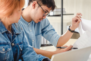 Obraz premium asian creative designer team casual meeting and brainstorming on desk with paperwork and online data on laptop in meeting room at modern office.business planning concept