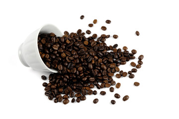 coffee beans spilling out of a cup isolated on white background.