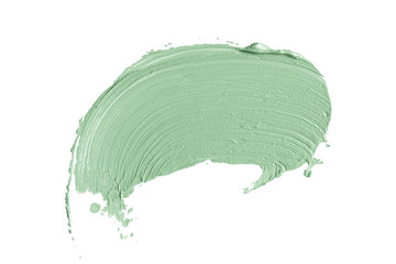 Color correcting concealer stroke isolated on white background. Light green corrector cream smudge smear swatch sample. Makeup base foundation creamy texture