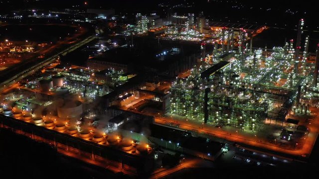 Aerial view night light oil terminal is industrial facility for storage of oil and petrochemical. oil manufacturing products ready for transport and business transportation. power electric plant.