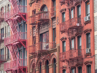 Obraz premium Facades of historic buildings in the Soho district of New York. The characteristic iron safety stairs on the facades