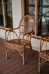 Fototapeta na wymiar Wicker chair is on autumn porch