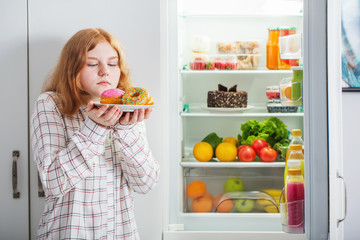 teenager girl at fridge with food