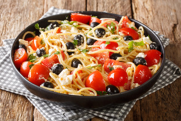 Vitamin fresh greek pasta spaghetti salad with cheese and vegetables close-up on a plate. horizontal