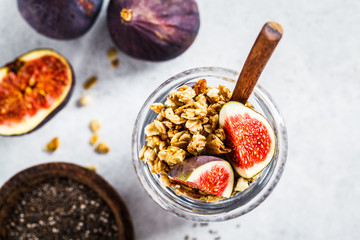 Chia pudding with figs and granola in jar, top view. Healthy vegan breakfast concept.