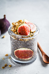 Chia pudding with figs and granola in jar. Healthy vegan breakfast concept.