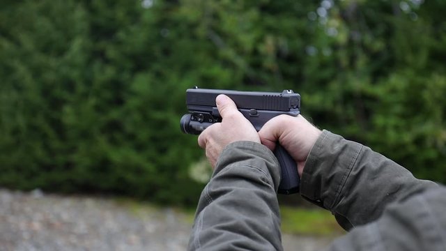 Closeup Man Shooting Pistol Handgun in Forest