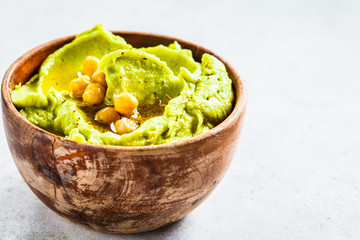 Avocado hummus in wooden bowl. Healthy vegan food concept.