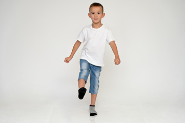 Full-length portrait on a white background of a cute boy child with Vitiligo disease - a violation...