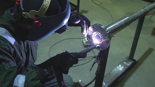 Weld worker welding with tig welder with wearing a safety industrial mask (Kilang di Malaysia)