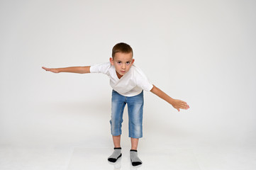 Full-length portrait on a white background of a cute boy child with Vitiligo disease - a violation...