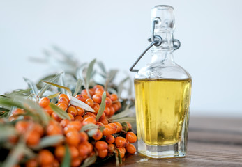 Leaves and berries of orange sea ​​buckthorn on wooden table background