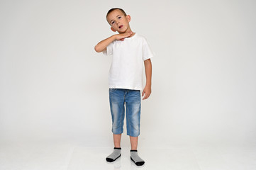 Full-length portrait on a white background of a cute boy child with Vitiligo disease - a violation...
