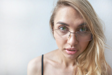 Fototapeta premium Charming girl with glasses looking at the camera, shot at wide angle