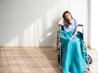 Asian beautiful young patient woman sitting on wheelchair equipment and recovery body after...