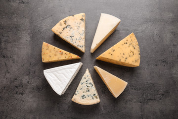 Flat lay composition with different kinds of cheese on grey background