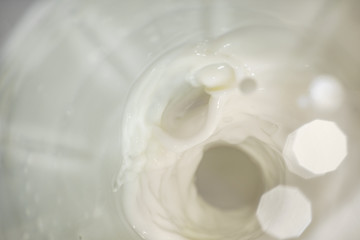 Fototapeta na wymiar Background with flowing white milk with bokeh, soft focus