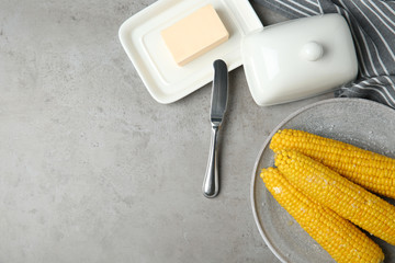 Flat lay composition with boiled corn cobs on light grey table. Space for text