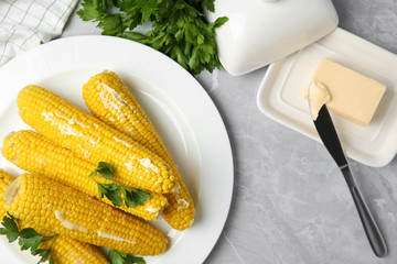 Flat lay composition of boiled corn cobs on light grey marble table