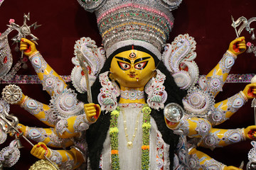 Goddess Durga idol at decorated Durga Puja pandal, shot at colored light, at Kolkata, West Bengal,...
