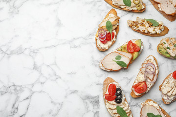 Different delicious chicken bruschettas on white marble table, flat lay. Space for text